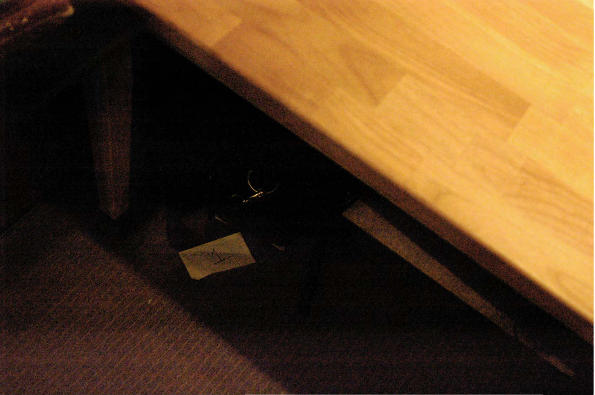 FBI search photo of Item 1 placed under the desk &mdash; the camera is not visible in the shadow